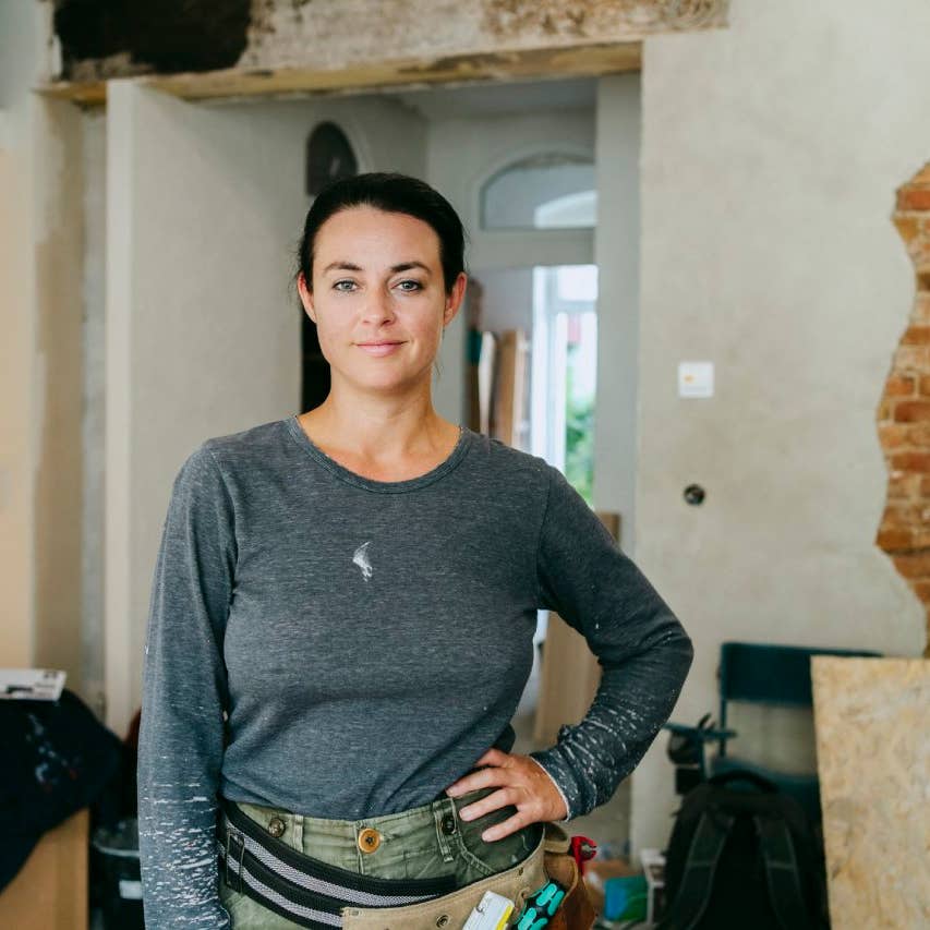 Portrait of confident female construction manager standing with hand on hip at construction site
