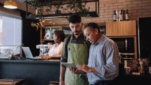 Coffee shop owner talking to employee