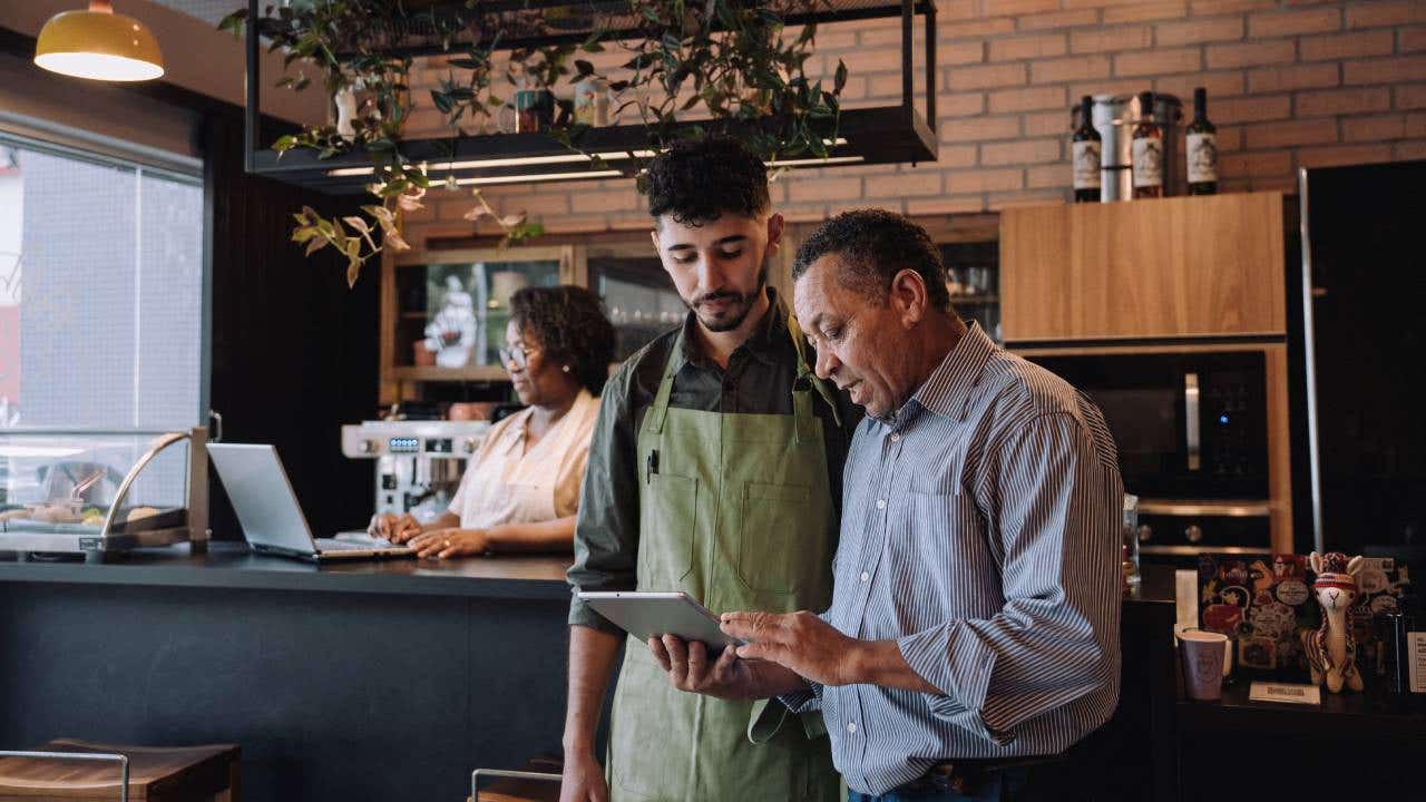 Coffee shop owner talking to employee