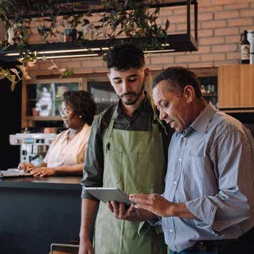 Coffee shop owner talking to employee
