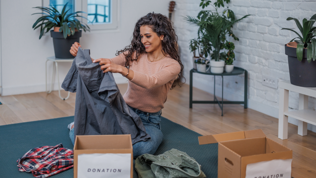 A young woman inspects the clothes she is going to donate.