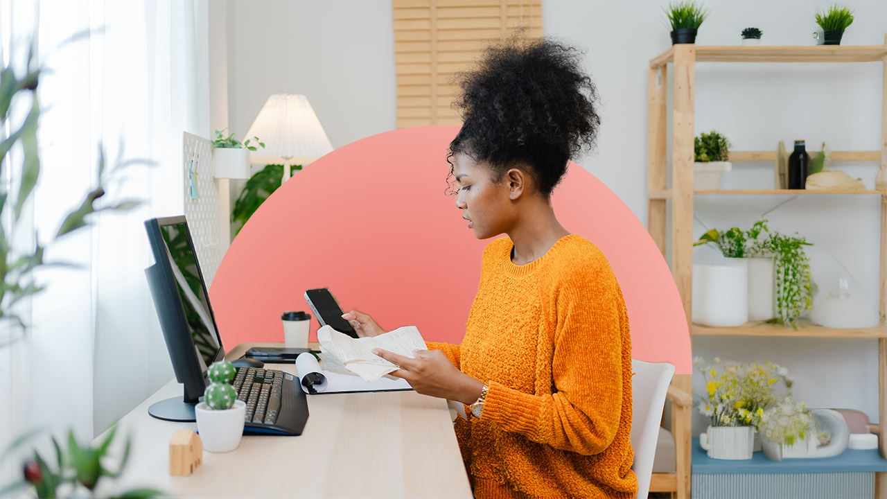 Young woman sits at her home office working on her finances.