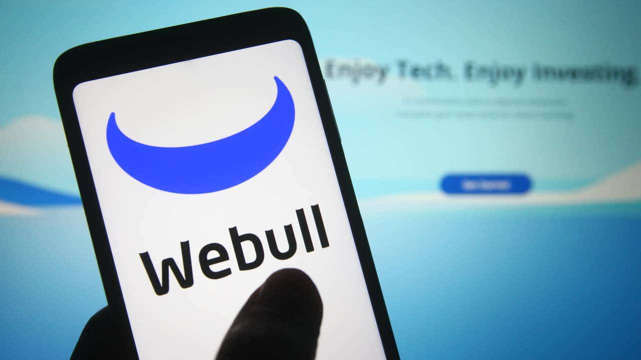 A Webull logo is seen on a smartphone.