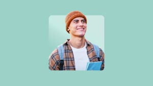 white male wearing orange beanie, flannel shirt over white t-shirt looking off into the distance