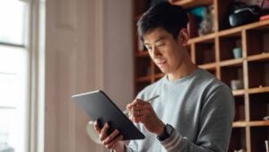 A young man compares brokerages on his iPad.