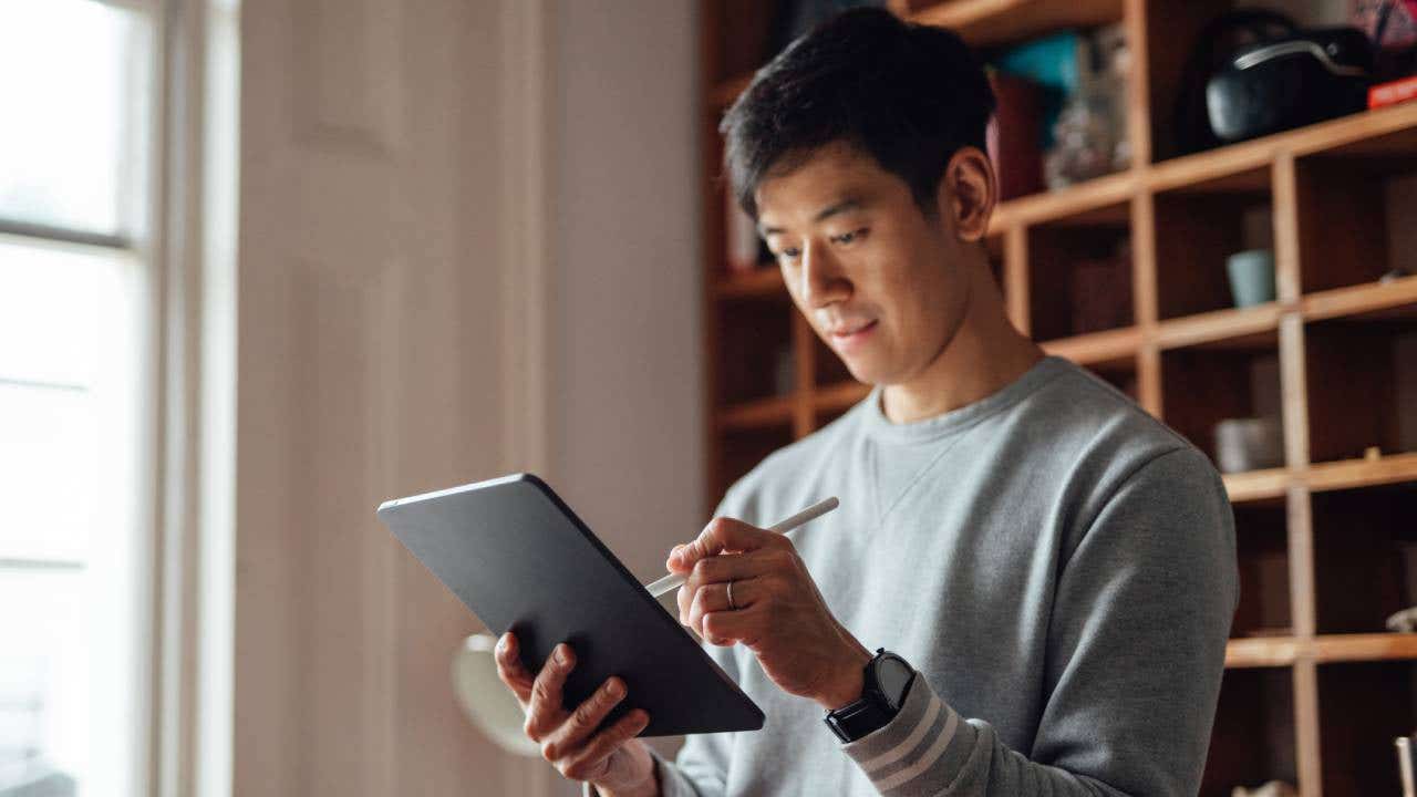 A young man compares brokerages on his iPad.