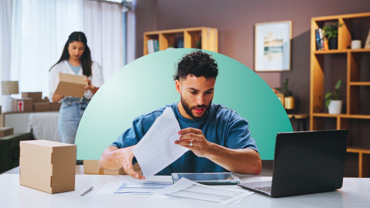 A man reviews papers and his laptop screen, with a teal half-circle design element behind him.