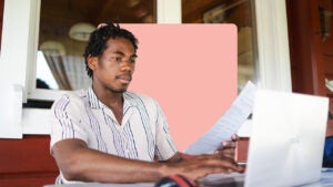 a design image of a young man on his laptop and holding a piece of paper