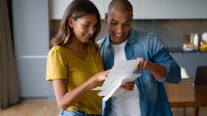 Excited Latin American couple looking at a letter.