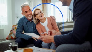 Older couple sitting in their living room with their financial advisor