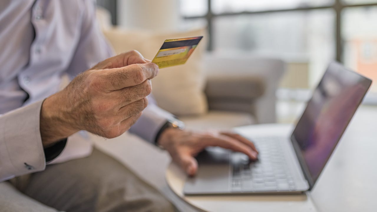 An older man holding a credit card