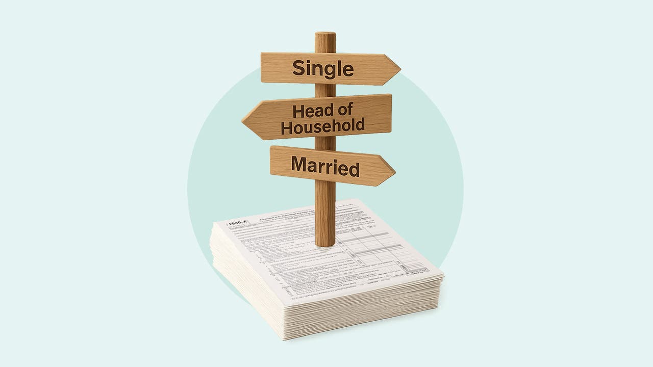 Illustration showing a sign with different arrows pointing to single, head of household and married, sitting on top of a stack of tax forms.