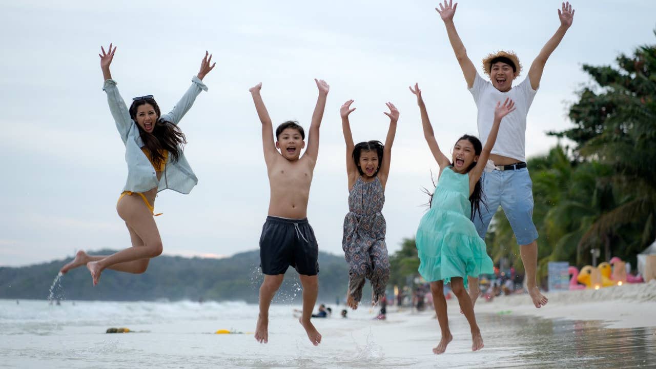 Asian Family Jumping at the beach