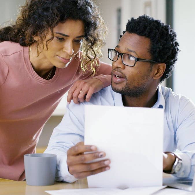 Couple discussing some important things at a table with laptop and documents in front of them.