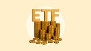 The letters ETF sit on top of a pile of coins on a yellow background.