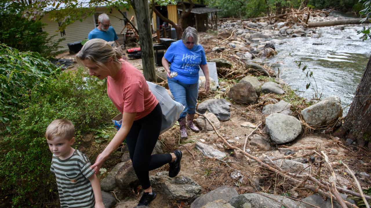 A family removes items from their home in the aftermath of Hurricane Helene on Sept. 30, 2024 in Old Fort, North Carolina.