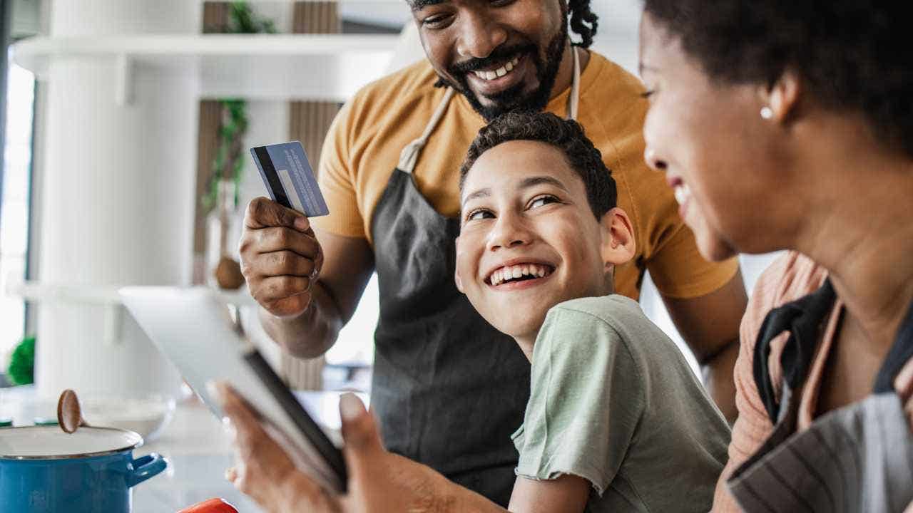 Young boy and his parents are in the kitchen ordering groceries